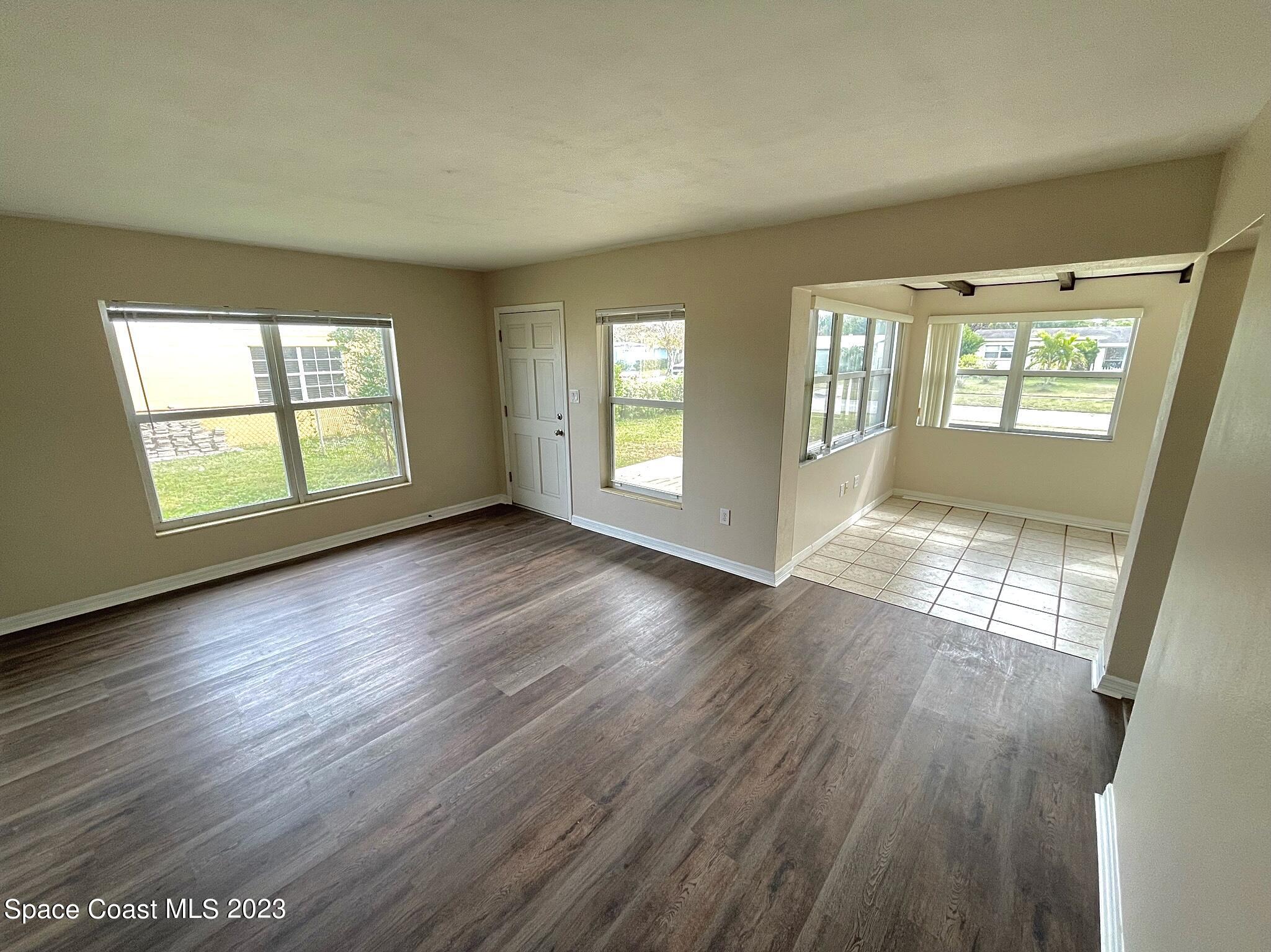 1820 Harrison Avenue Melbourne, FL 32935 - Photo 5 of 20 an empty room with wooden floor and windows