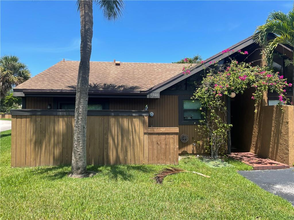a backyard of a house with plants and tree