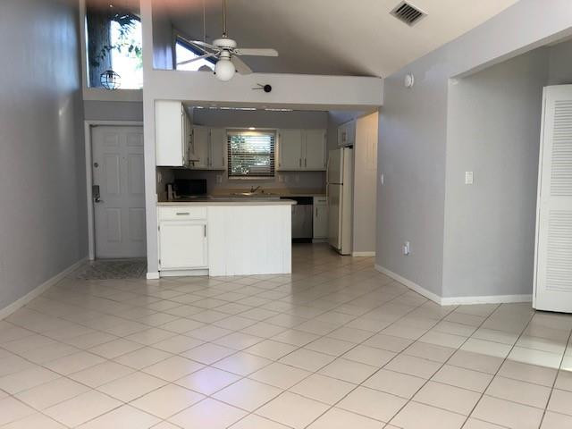 9301 Southwest 130th Street Miami, FL 33176 - Photo 4 of 13 a view of a kitchen with kitchen island white cabinets and refrigerator