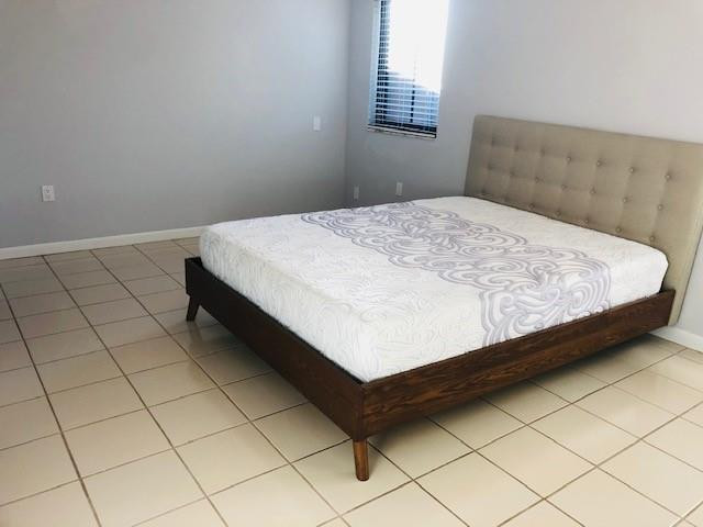 9301 Southwest 130th Street Miami, FL 33176 - Photo 6 of 13 a bed sitting in a bedroom next to a window