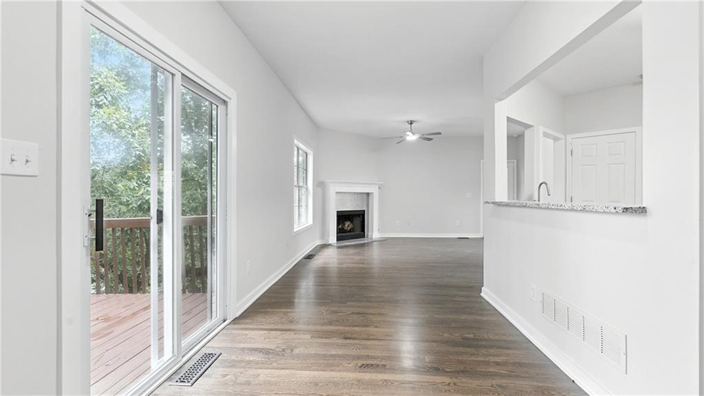 730 Reeves Lake Drive Southwest Marietta, GA 30064 - Photo 5 of 16 an empty room with wooden floor and fireplace