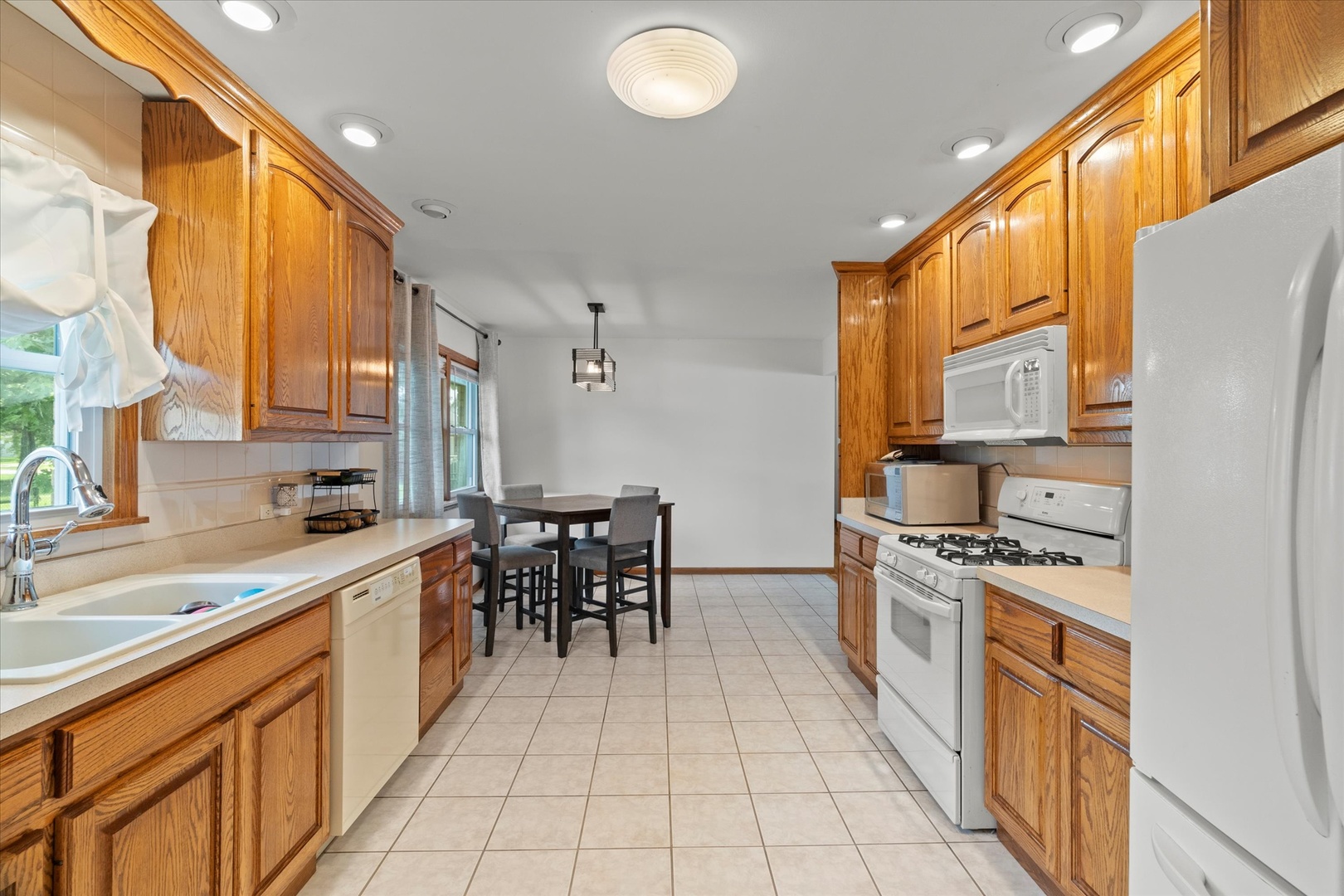5661 Roosevelt Street Monee, IL 60449 - Photo 5 of 20 a kitchen with stainless steel appliances granite countertop a stove a sink and a refrigerator