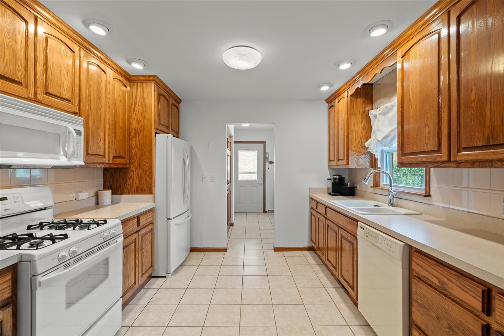 5661 Roosevelt Street Monee, IL 60449 - Photo 7 of 20 a kitchen with a sink stove and refrigerator