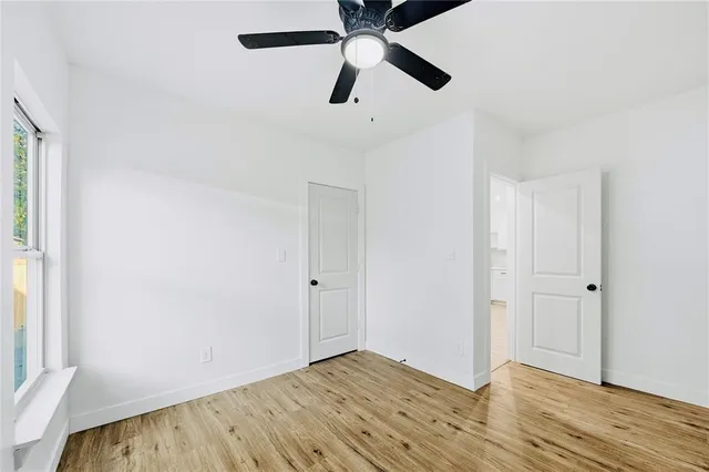 an empty room with a window and wooden floor