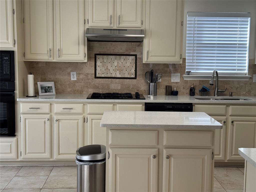 3448 Lark Meadow Way Dallas, TX 75287 - Photo 26 of 39 a kitchen with white cabinets and a stove with a sink