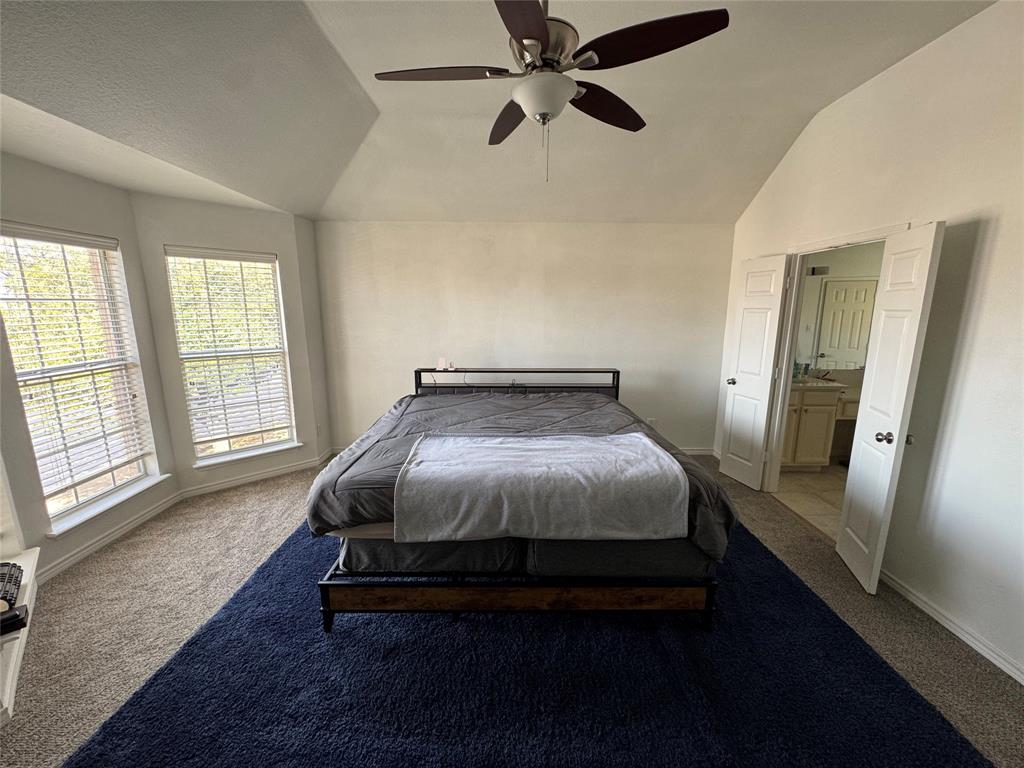 3448 Lark Meadow Way Dallas, TX 75287 - Photo 27 of 39 a spacious bedroom with a bed and wooden floor