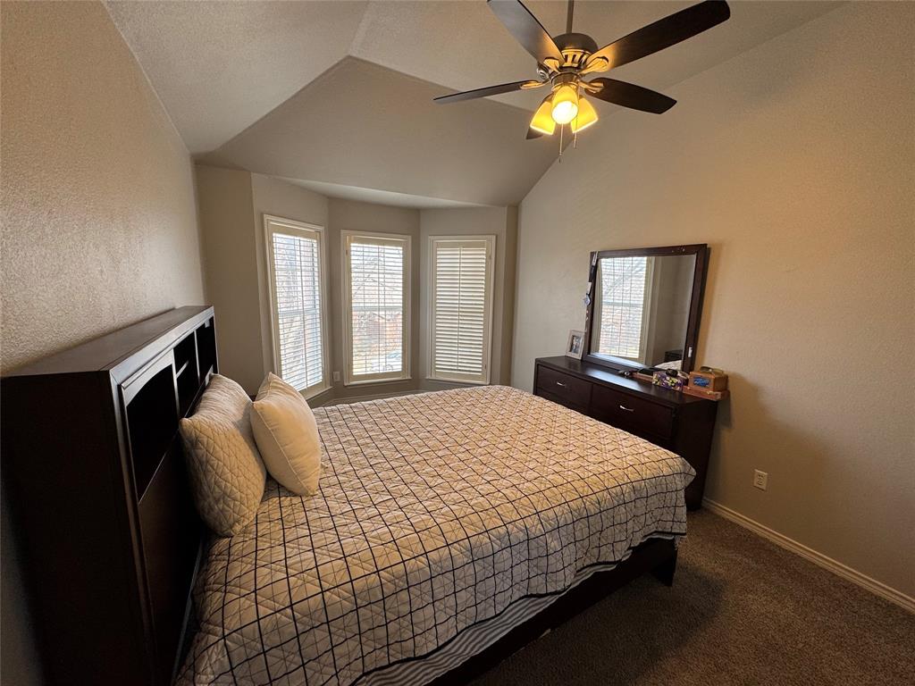 3448 Lark Meadow Way Dallas, TX 75287 - Photo 37 of 39 a bedroom with a bed and a chandelier