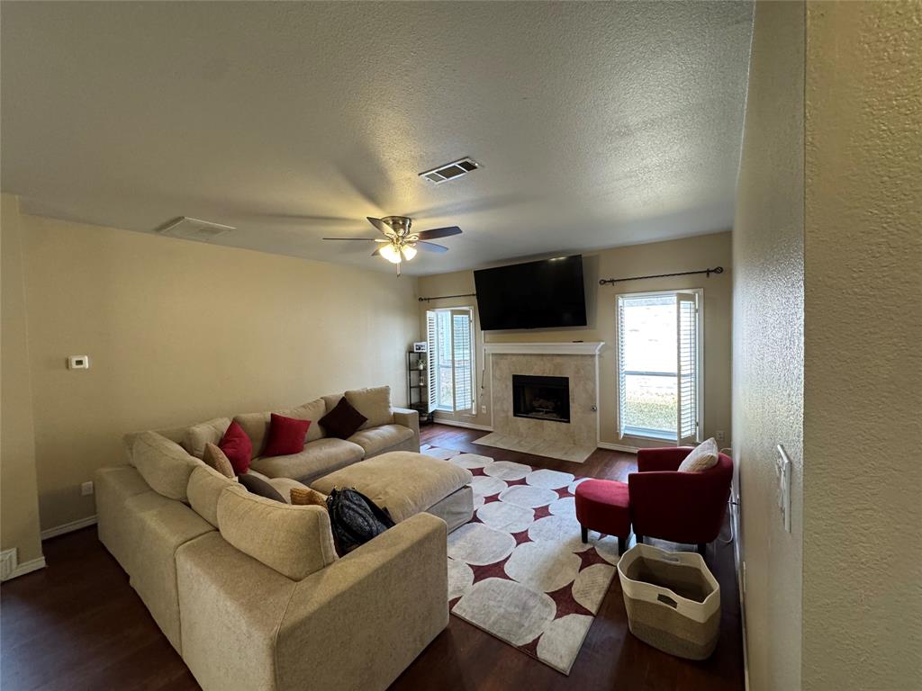 3448 Lark Meadow Way Dallas, TX 75287 - Photo 5 of 39 a living room with furniture a fireplace and a flat screen tv
