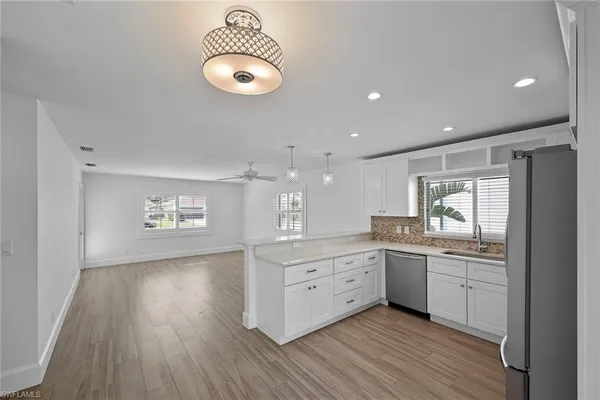 a kitchen with stainless steel appliances granite countertop a sink cabinets and wooden floor
