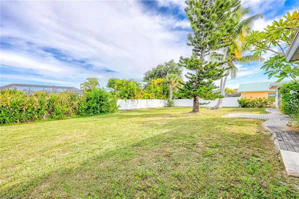 a view of a house with a big yard and potted plants
