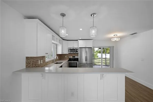 a kitchen with stainless steel appliances a microwave a stove and white cabinets