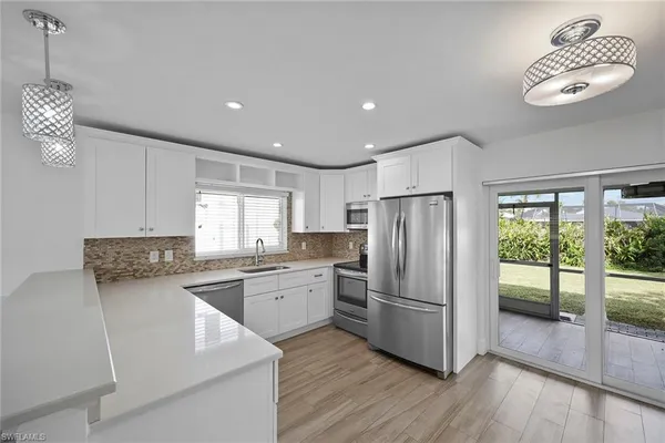 a kitchen with stainless steel appliances granite countertop a refrigerator and a stove top oven