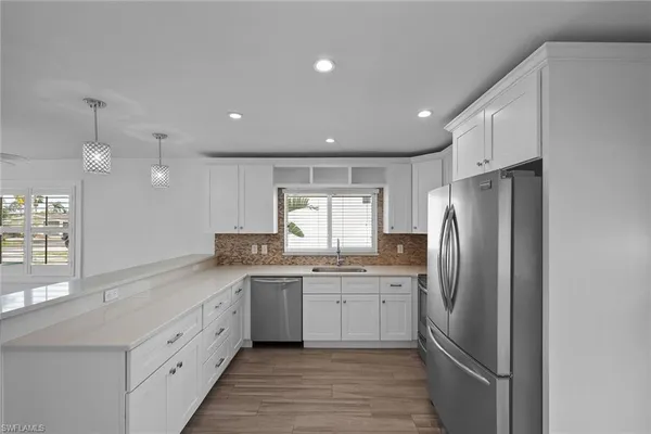 a kitchen with stainless steel appliances granite countertop a refrigerator sink and cabinets