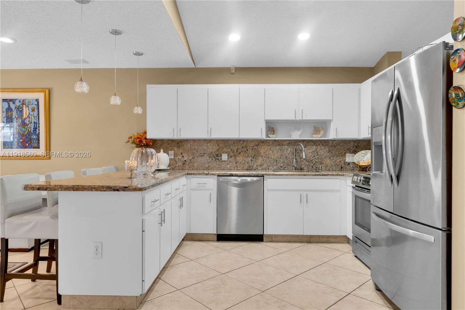 11365 Southwest 143rd Court Miami, FL 33186 - Photo 15 of 40 a kitchen with granite countertop a sink stainless steel appliances and white cabinets