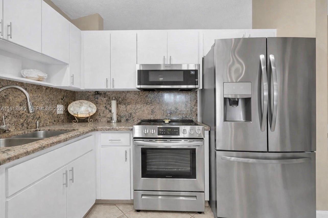 11365 Southwest 143rd Court Miami, FL 33186 - Photo 20 of 40 a kitchen with cabinets and stainless steel appliances