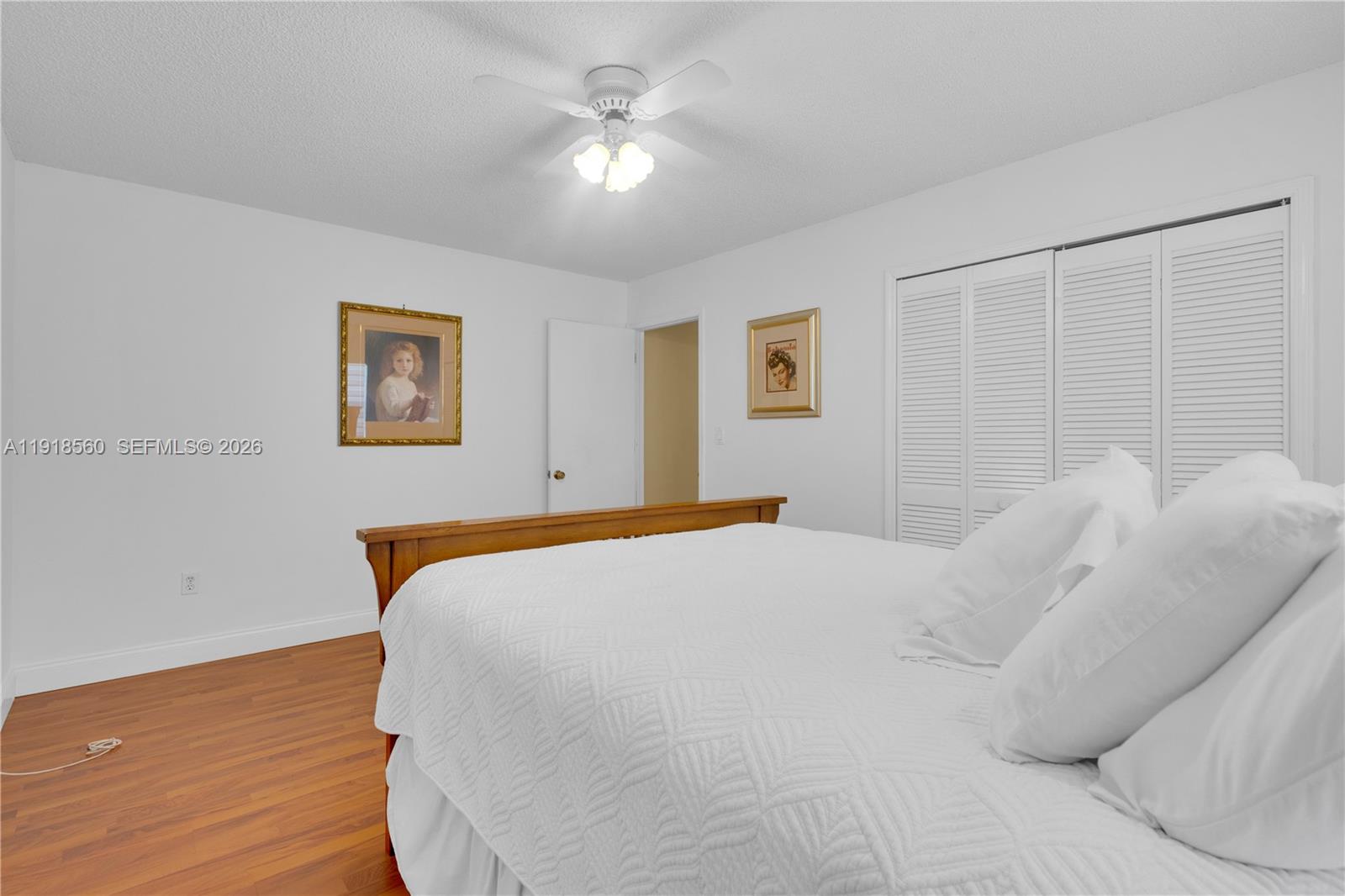 11365 Southwest 143rd Court Miami, FL 33186 - Photo 24 of 40 a bed sitting in a bedroom and a chandelier