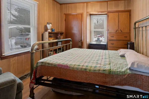 a bedroom with a bed and wooden floor