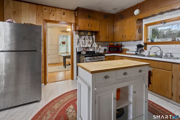 a kitchen with a refrigerator sink and cabinets