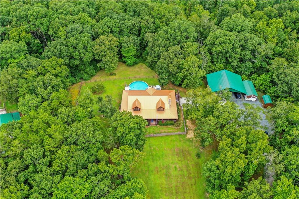 a aerial view of a house with a yard and trees