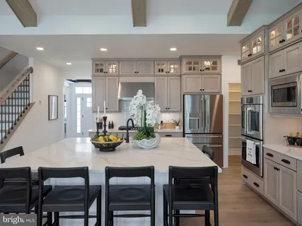 a kitchen with stainless steel appliances a table chairs and refrigerator