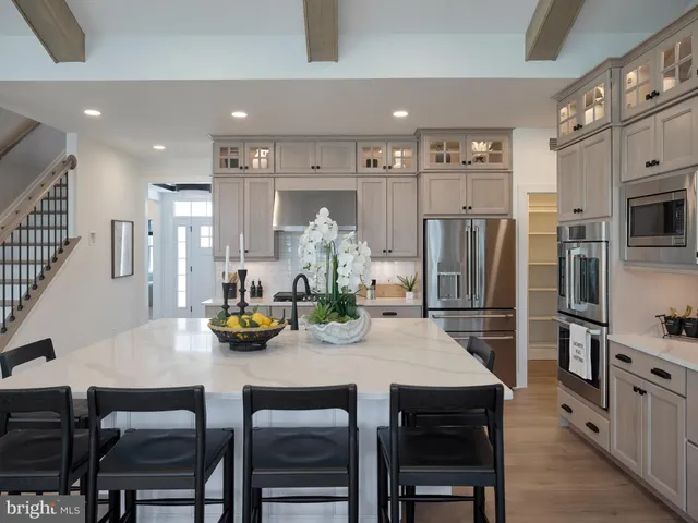 a kitchen with stainless steel appliances a table chairs and refrigerator