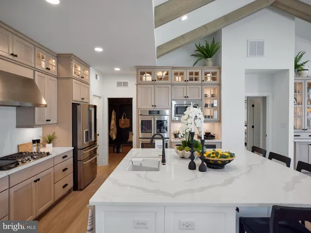 a kitchen with stainless steel appliances kitchen island granite countertop a refrigerator and stove