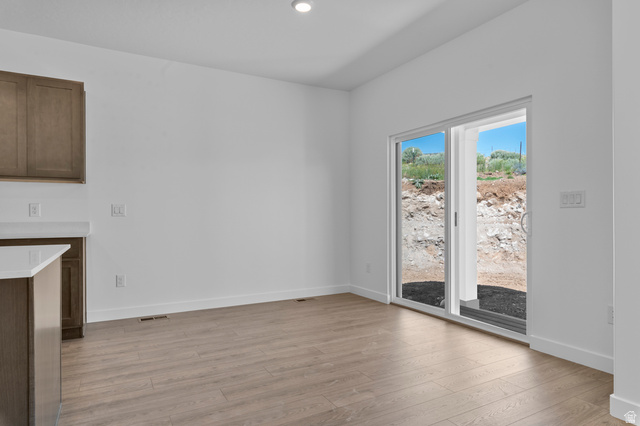 1338 West 2350 South, Unit 19 Perry, UT 84302 - Photo 5 of 14 Spacious room featuring wood-finish flooring, white walls, and a recessed ceiling light