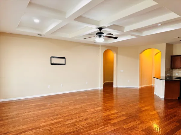 a view of an empty room with window and wooden floor