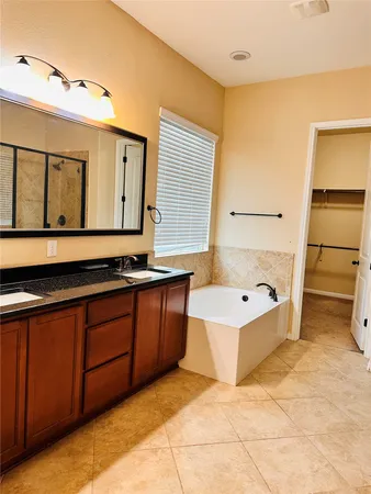 a spacious bathroom with a tub sink and mirror