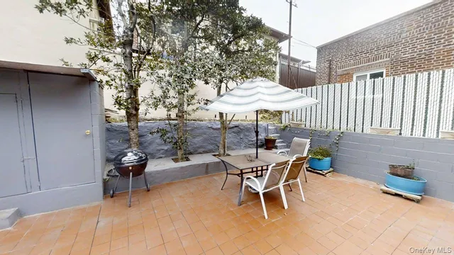 a view of a patio with a table and chairs under an umbrella