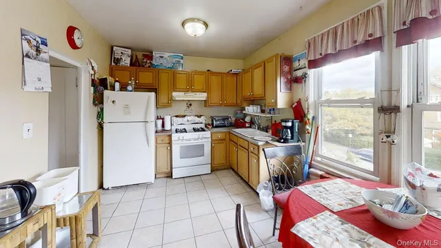 a kitchen with a refrigerator a stove a sink dishwasher and white cabinets with wooden floor