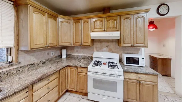 a kitchen with granite countertop cabinets stainless steel appliances and a counter space