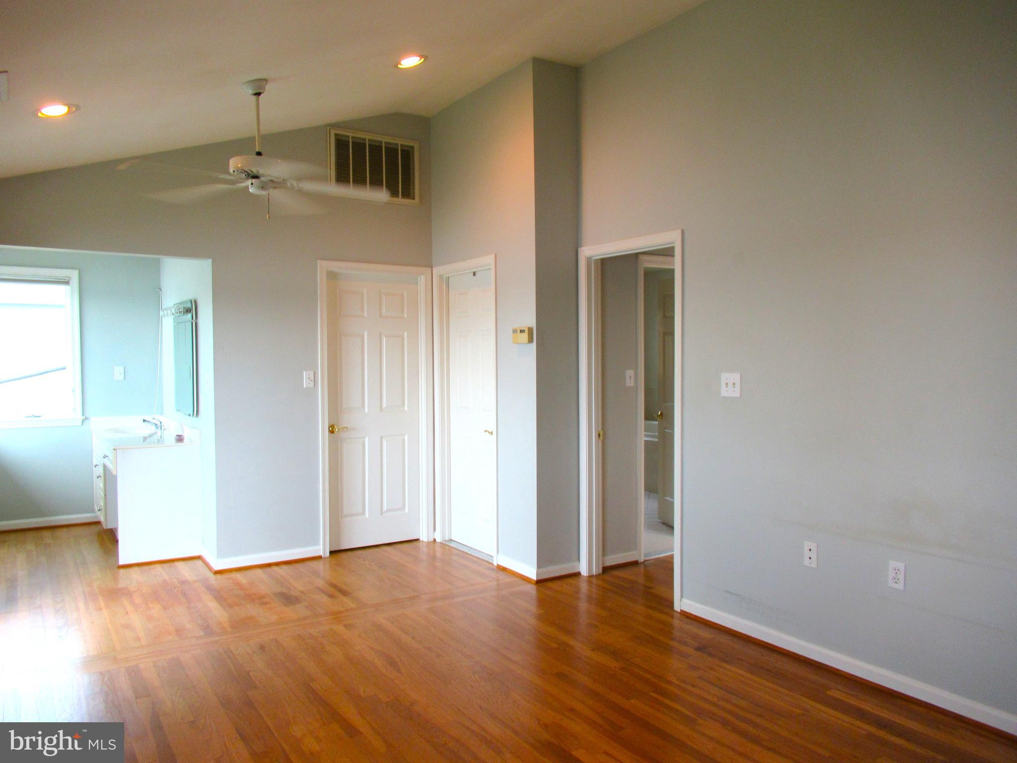 7638 Laurel Drive Pasadena, MD 21122 - Photo 21 of 51 an empty room with wooden floor and windows