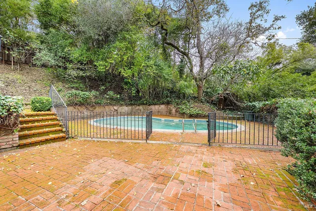 a view of a swimming pool with a patio and a yard