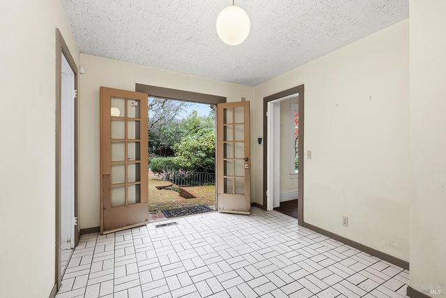 a view of an empty room with stairs and a window