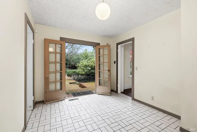 a view of an empty room with stairs and a window