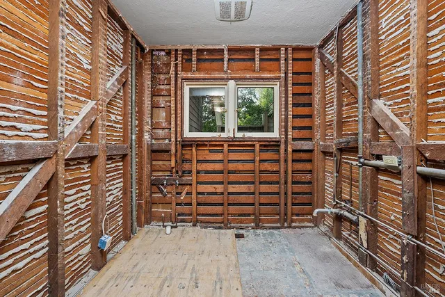 a view of an empty room with a window and tub