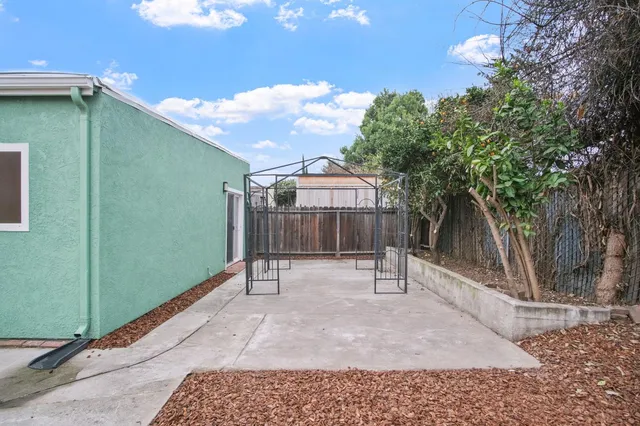 a view of a house with backyard and a tree