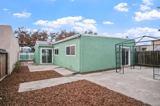 a backyard of a house with basket ball court tables and chairs