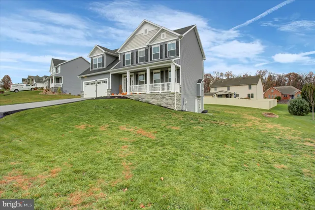 a view of a house with a big yard and large trees