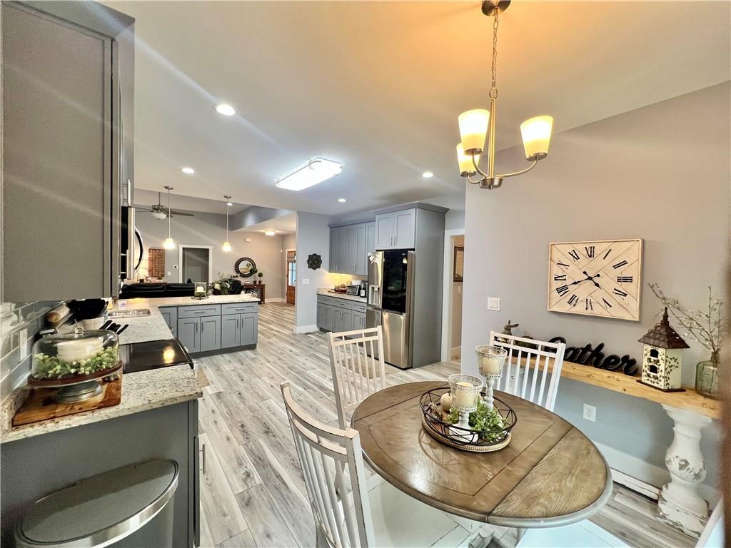 566 Clinton Drive Temple, GA 30179 - Photo 11 of 40 a kitchen with stainless steel appliances granite countertop a stove a kitchen island a dining table and chairs with wooden floor
