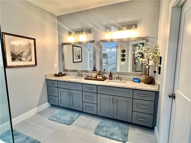 a bathroom with double vanity sink and a mirror