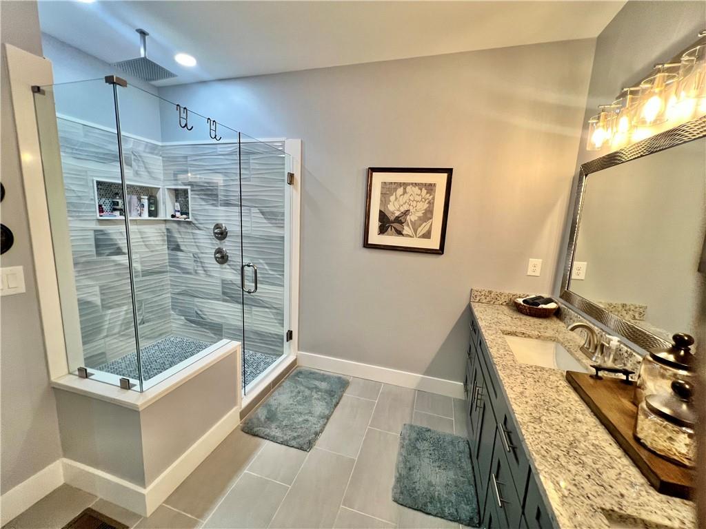 566 Clinton Drive Temple, GA 30179 - Photo 18 of 40 a bathroom with a granite countertop sink a mirror a bathtub and shower