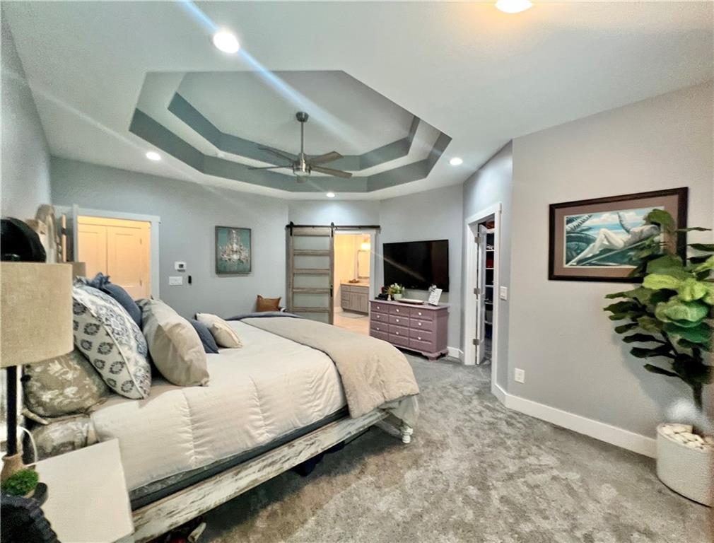 566 Clinton Drive Temple, GA 30179 - Photo 20 of 40 a bedroom with a large bed a flat tv screen and a dresser