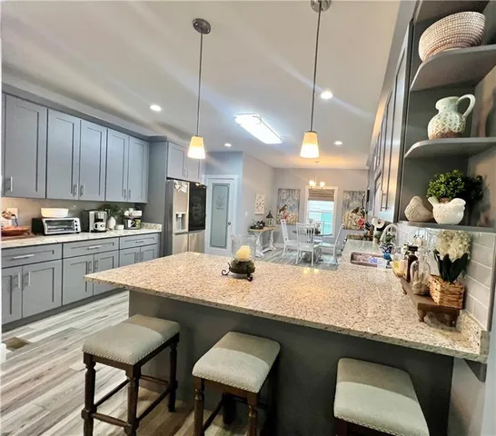 a kitchen with granite countertop a table chairs stove and cabinets