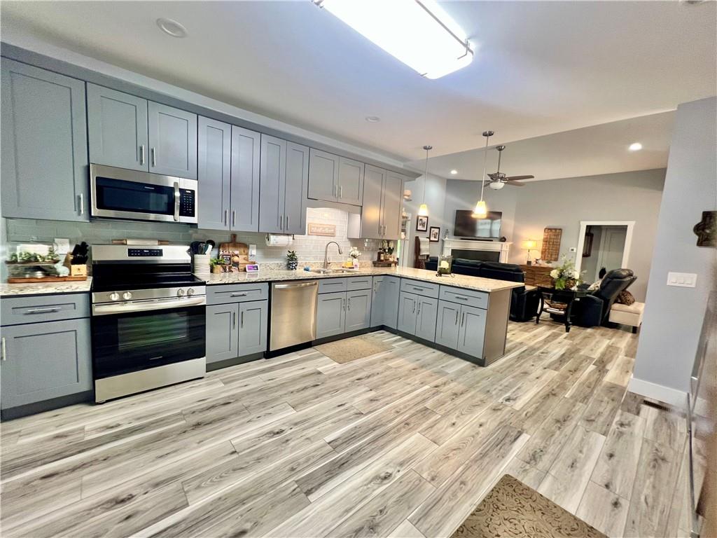 566 Clinton Drive Temple, GA 30179 - Photo 10 of 40 a kitchen with stainless steel appliances granite countertop a stove top oven a sink dishwasher and white cabinets with wooden floor