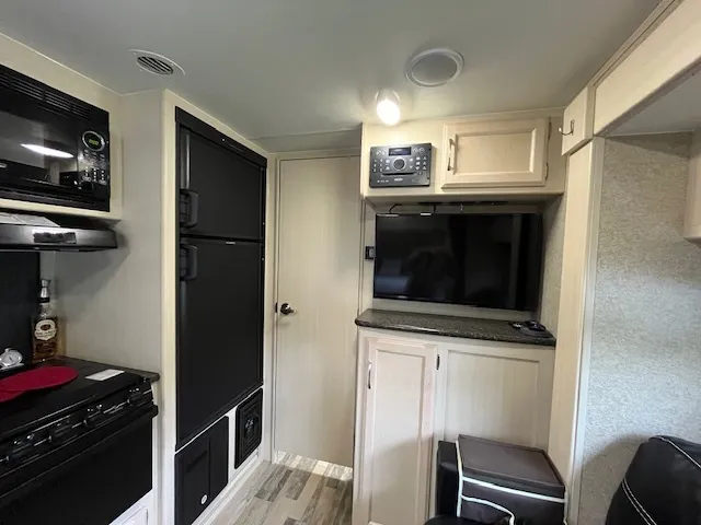a kitchen with a refrigerator and a stove top oven