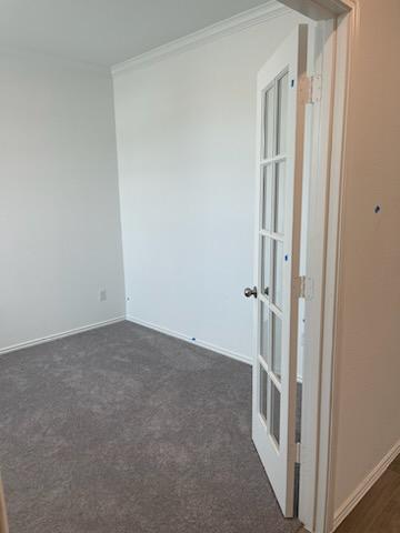 1509 Hope Rnch Road Leander, TX 78641 - Photo 5 of 25 Empty room featuring ornamental molding, baseboards, and dark carpet