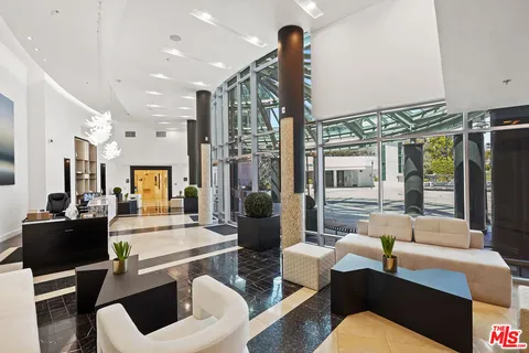 a dining room with wooden floor a chandelier a glass table and windows