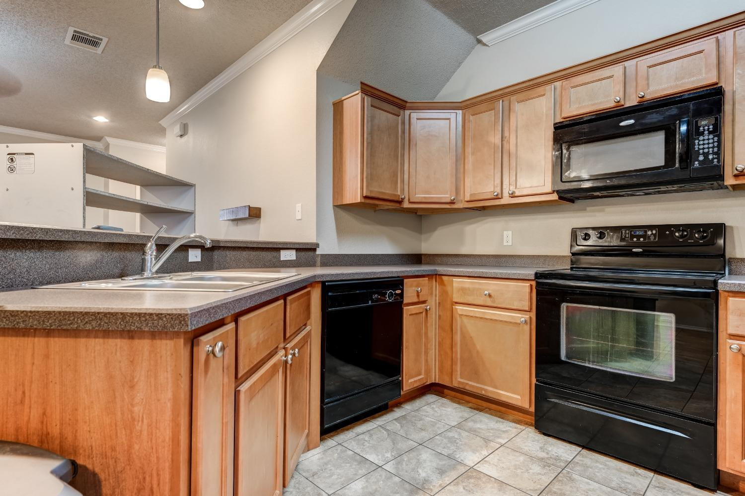 2102 Main Street, Unit 5 Lubbock, TX 79401 - Photo 16 of 27 a kitchen with stainless steel appliances granite countertop a sink stove and microwave